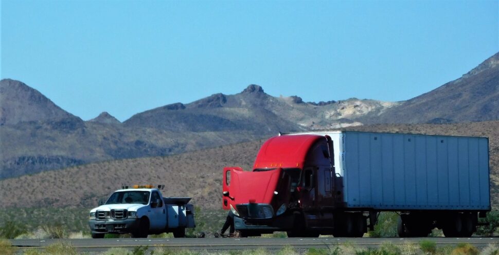 Collision of a semi truck with box trailer a passenger car on the highway road, as a result of which both cars were damaged, await the arrival of the police to draw up an accident report